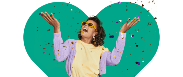 Femme souriante et lançant des confettis en l’air sur un fond en forme de cœur